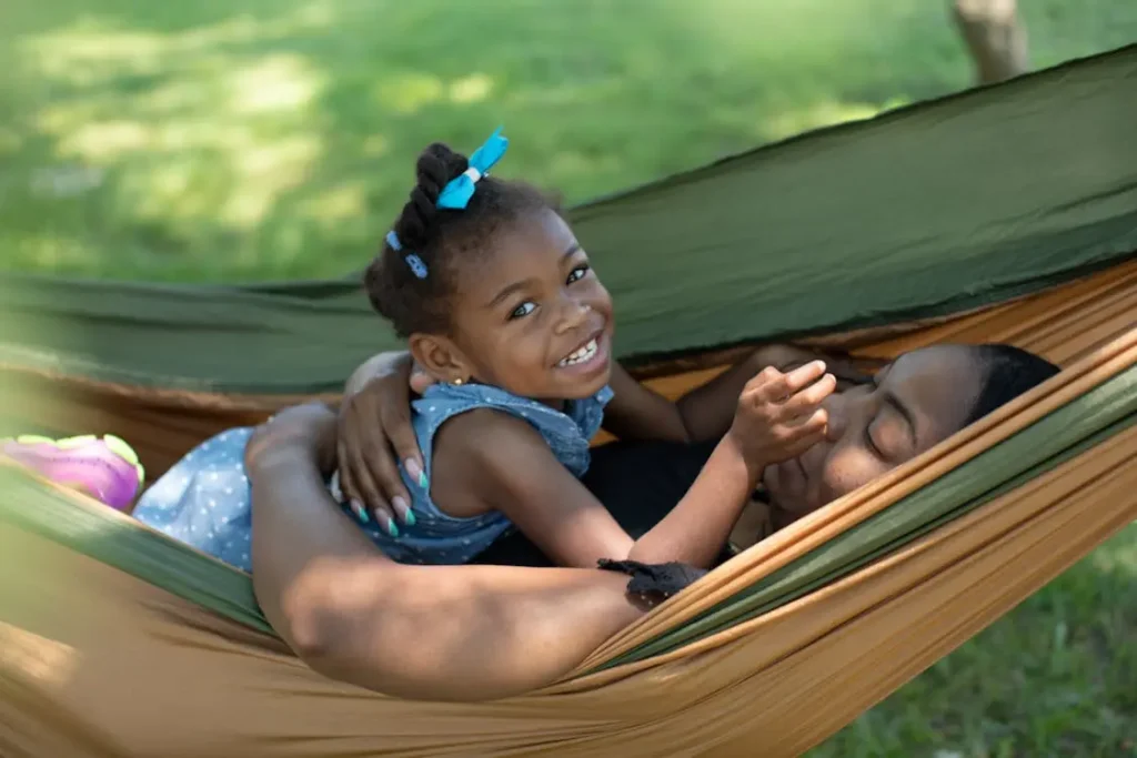 Child & mum happily playing and cuddlingin a hammock
