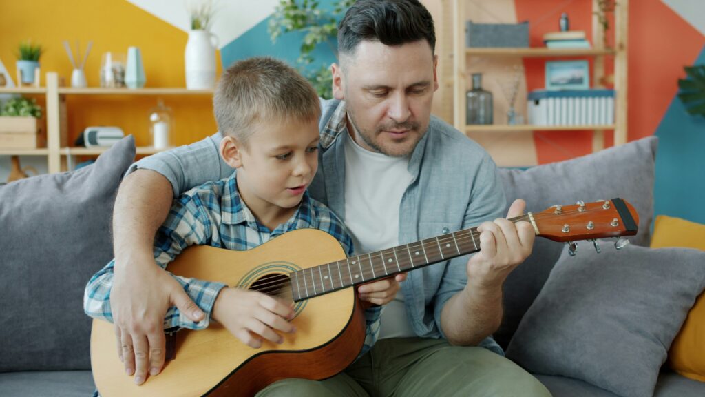 Dad and son learning guitar together